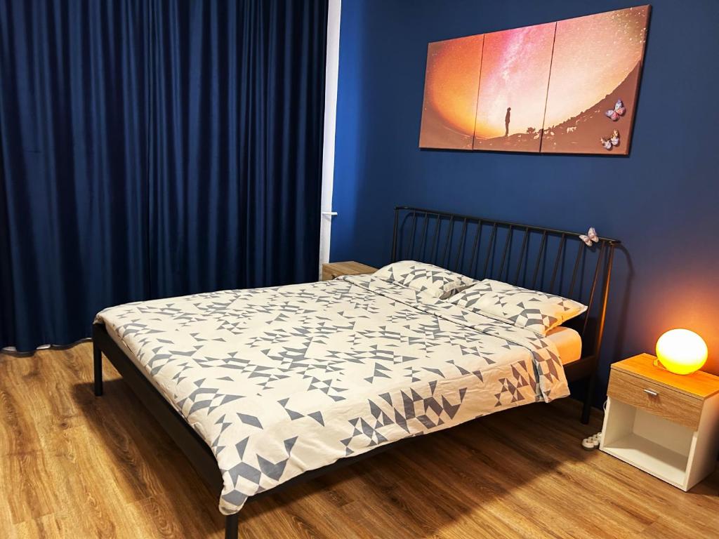 a bedroom with a bed with a blue wall and a bedskirtspectspectspects at Marius Studio in Braşov
