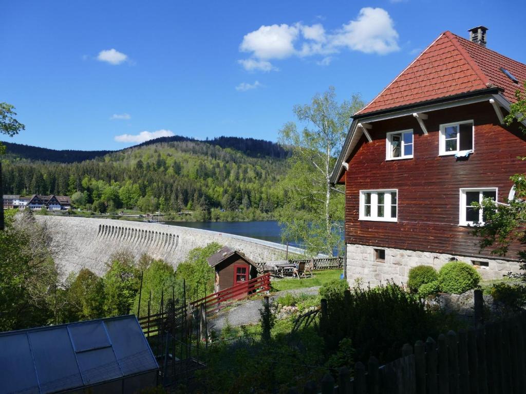 een huis met een rood dak en een waterlichaam bij Zum Alten Wärterhaus in Forbach