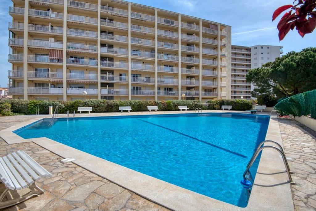 una piscina frente a un gran edificio en Apartamento con piscina junto a la playa, en Sant Antoni de Calonge