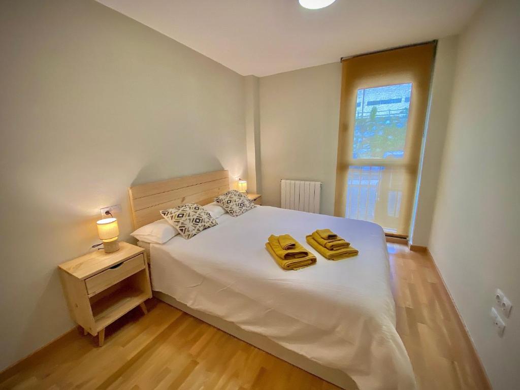 una camera da letto con un letto con due asciugamani gialli di El Rinconcito de Sabi a Sabiñánigo