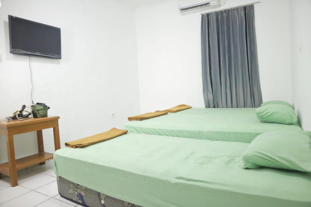 Postel nebo postele na pokoji v ubytování Hotel Bhakti Syariah