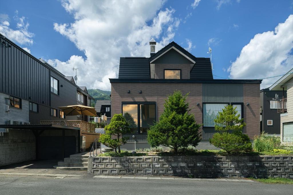 a brick house with a black roof at Casi 15 in Furano