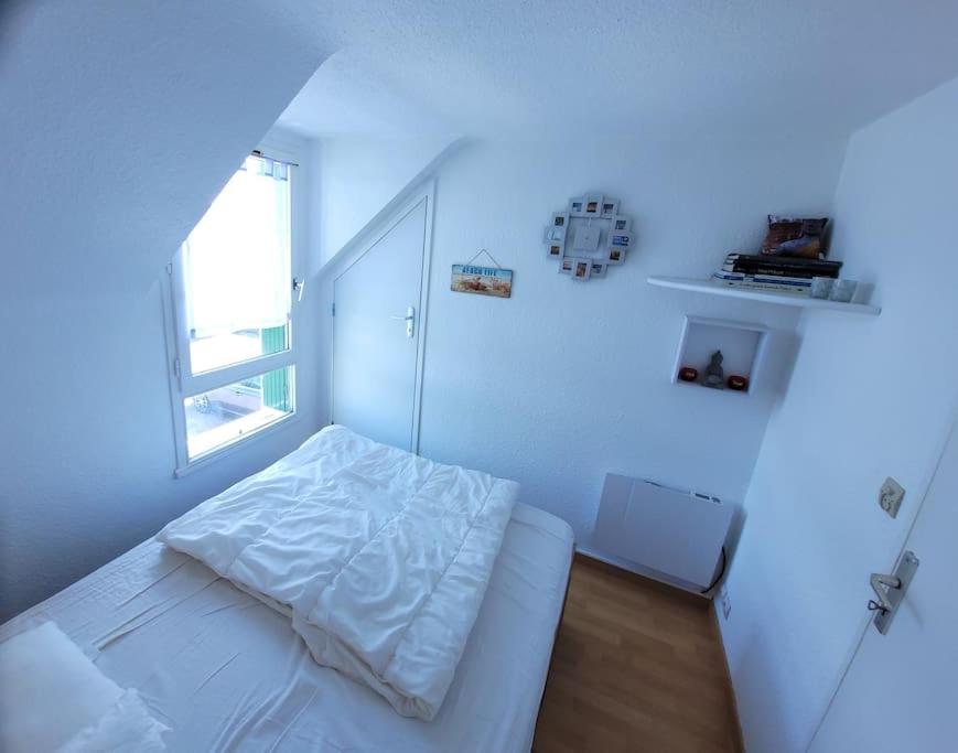 biała sypialnia z łóżkiem i oknem w obiekcie Le Cocon Croisicais - Les Gîtes de la Côte d'Amour w mieście Le Croisic