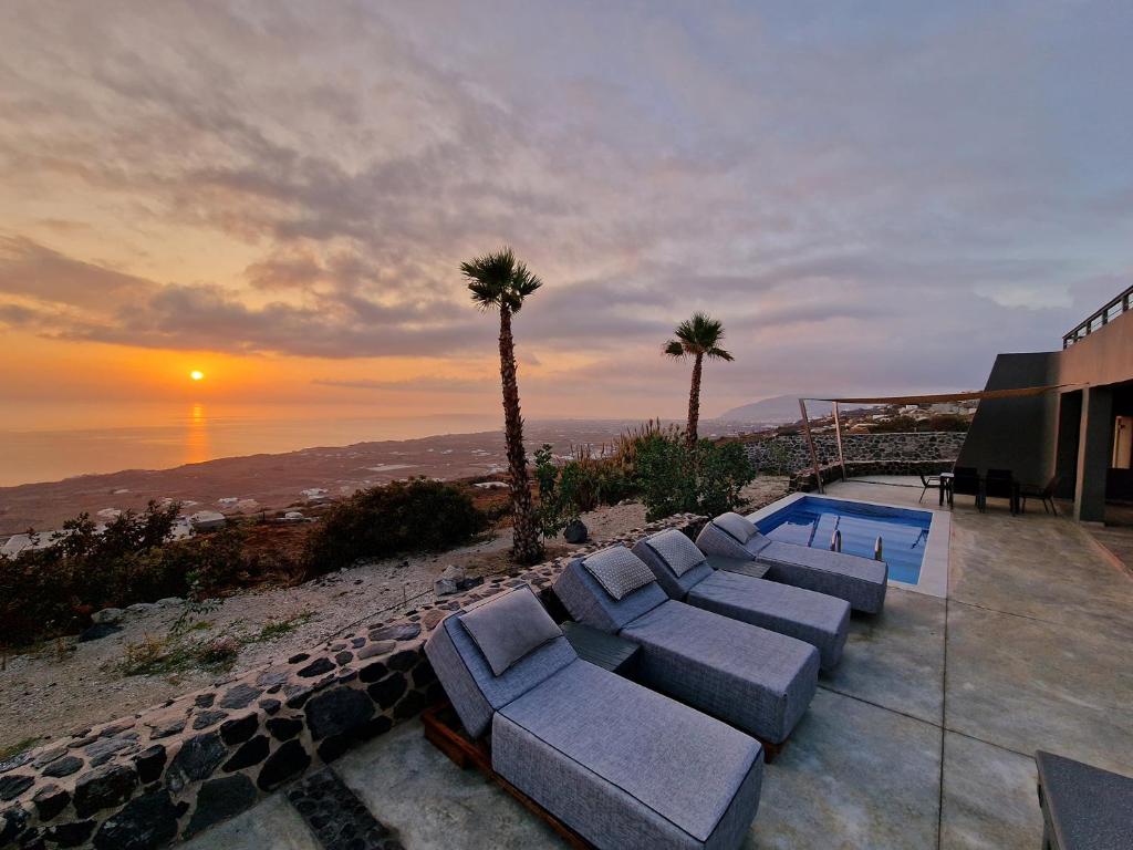 a patio with couches and a view of the ocean at Theano Cave Suites & Villas in Imerovigli