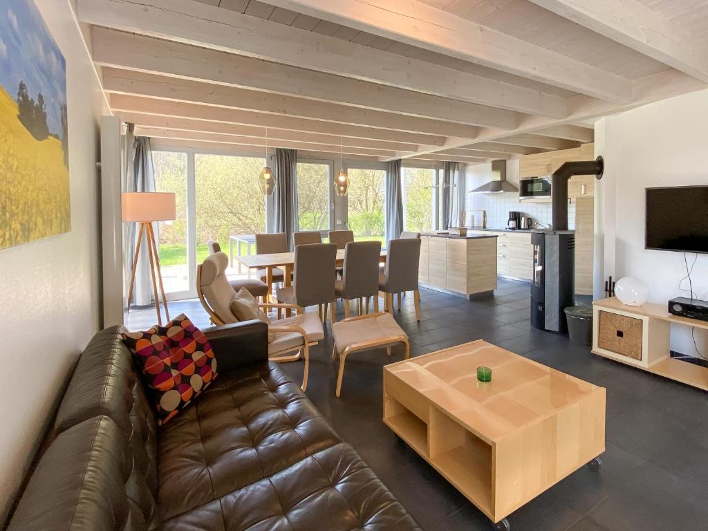 un soggiorno con divano in pelle marrone e tavolo di Familienhaus Wiesengeflüster W11 - kinderfreundlich und nur 300 m zum Strand a Röbel