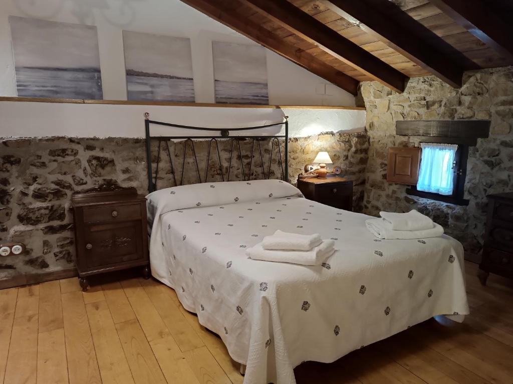 a bedroom with a bed with towels on it at La Casina Del Fornu in Pravia