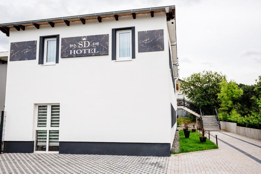 un bâtiment blanc avec un panneau indiquant un hôtel dans l'établissement SD Hotel, à Georgsmarienhütte