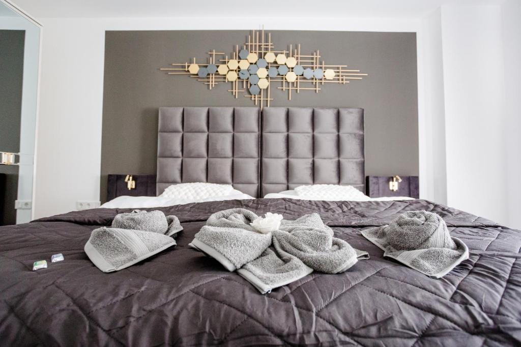 a bedroom with a bed with towels and a chandelier at SD Hotel in Georgsmarienhütte