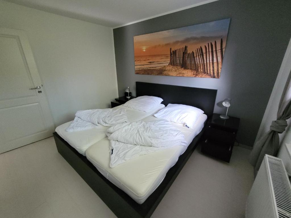 a bed in a bedroom with a picture on the wall at Ferienhaus Gammendorf in Gammendorf