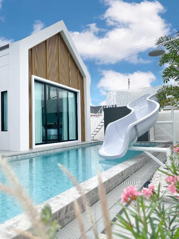a swimming pool with a slide next to a house at Harmonic HuaHin Pool Villa-3BR, 3 Bath, 2 Kitchen in Hua Hin