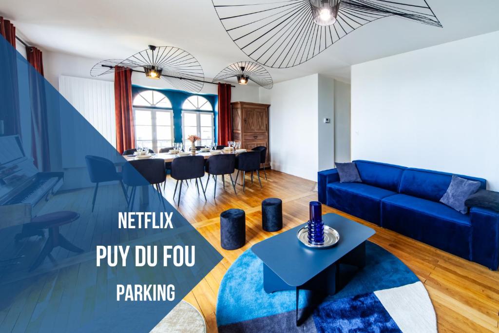 a living room with a blue couch and a table at Jolie m'Home*Le Puy du Fou in Mauléon