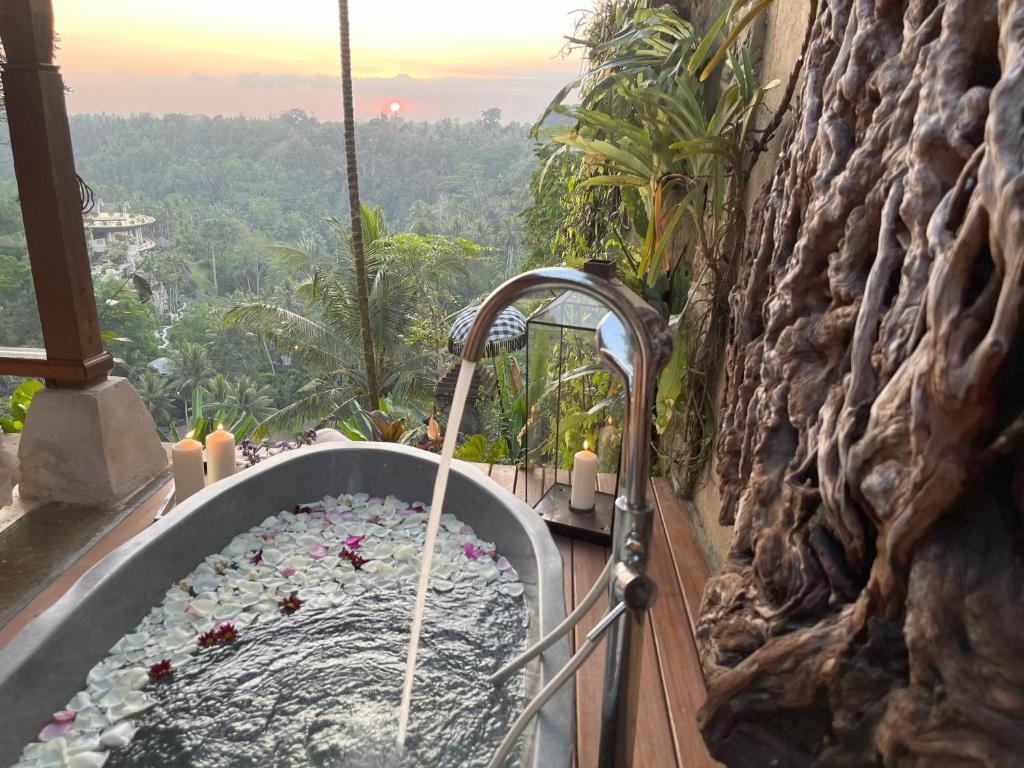eine Badewanne mit Blumen in einer Steinwand in der Unterkunft Bali Maison in Ubud