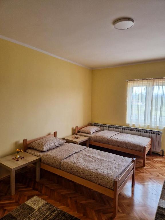 a room with two beds and a window at Prenoćište Mali Raj in Valjevo
