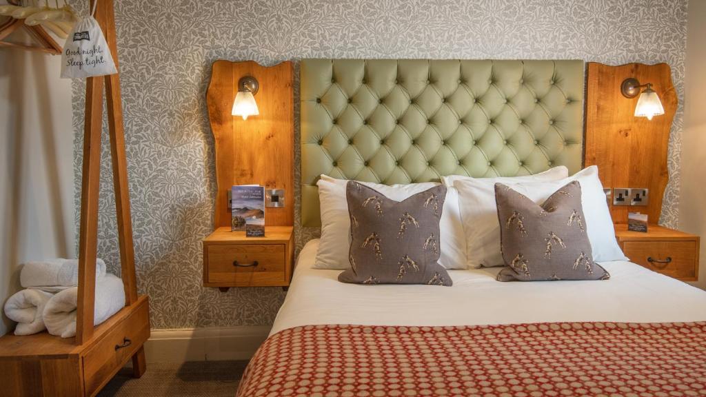 a bedroom with a bed with a large headboard and pillows at Royal Oak at Keswick in Keswick