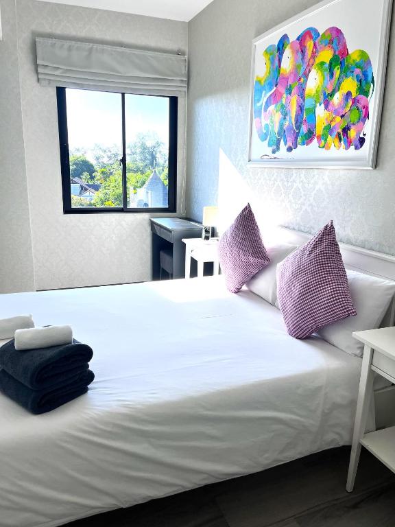 a bedroom with a large white bed with purple pillows at В7 НОВАЯ КВАРТИРА ВАТСАП669З582I976 можно РУБЛЯМИ in Nai Yang Beach