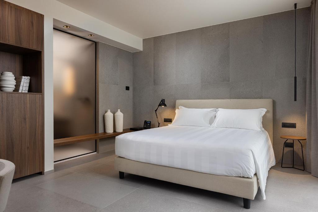 a bedroom with a large white bed and a desk at B21 Lifestyle Hotel in Bari