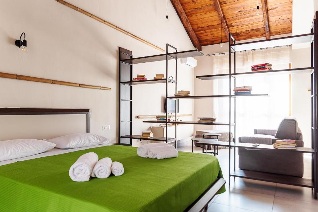 Schlafzimmer mit einem grünen Bett, einem Stuhl und einem Schreibtisch in der Unterkunft Borgo del Bambù in Perito
