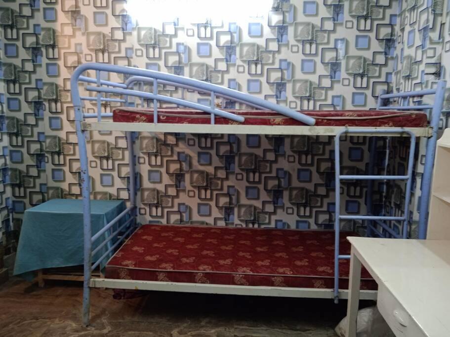 Venus Homestay في كولْكاتا: سرير بطابقين في غرفة مع ستارة