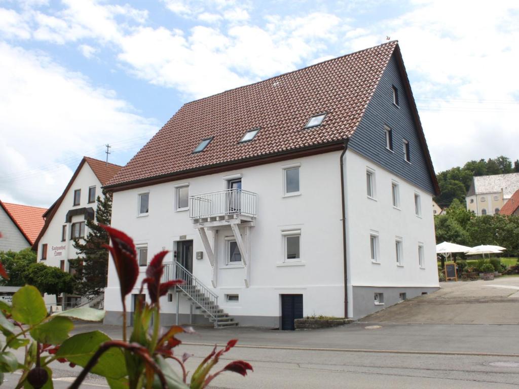 ein großes weißes Gebäude mit braunem Dach in der Unterkunft Landgasthof Lamm Ferienwohnungen in Burladingen