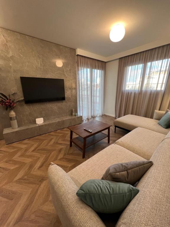 a living room with two couches and a flat screen tv at Natali's luxury apartment in Strovolos