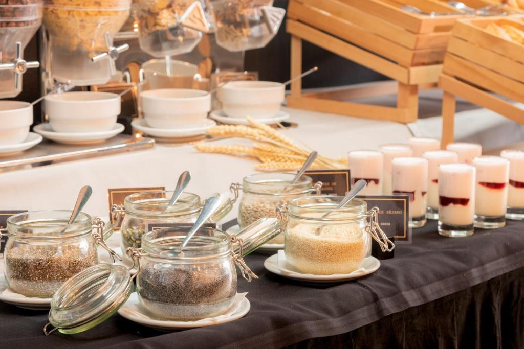 a table topped with jars of food and candles at Aqua Pedra Dos Bicos Design Beach Hotel - Adults Friendly in Albufeira