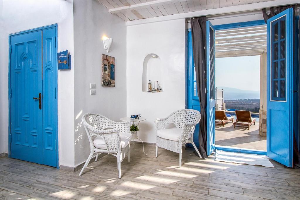 a room with blue doors and chairs and a table at VILLA NAYA Branch 3 - SANTORINI, Jerash in Rujm al Miḑmār