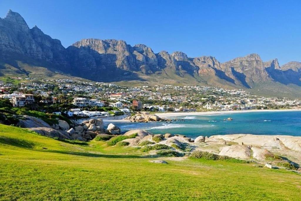 a view of a beach with mountains in the background at Cape Town, Sea Point, Beautiful 2 Bedroom Apartment @Tucked Away in Cape Town