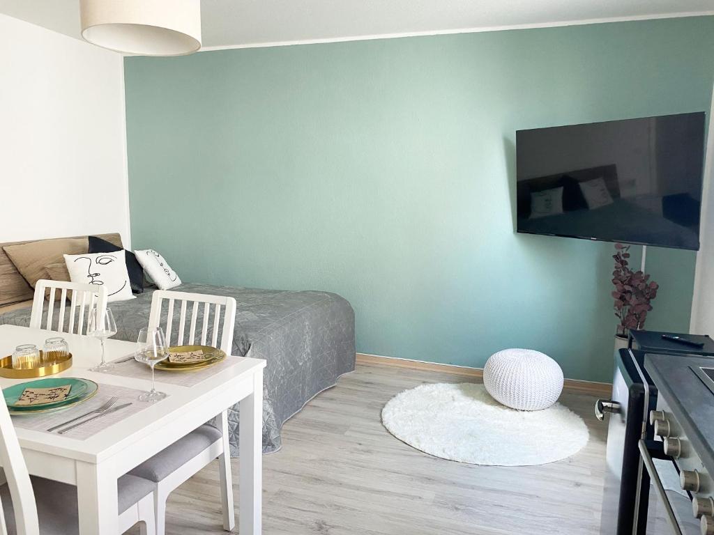 a living room with a table and a bed at Balcony-Appartement in Bielefeld