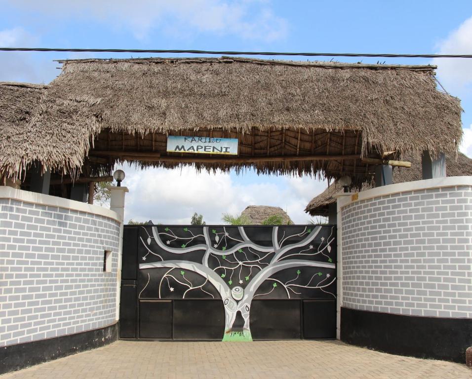eine Garage mit einem Tor mit einem gemalten Baum in der Unterkunft Mapeni Lodge in Kidenge