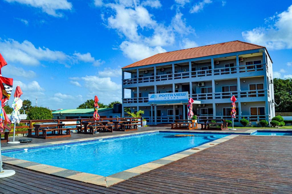 a hotel with a swimming pool in front of a building at Ponta View Hotel in Ponta do Ouro