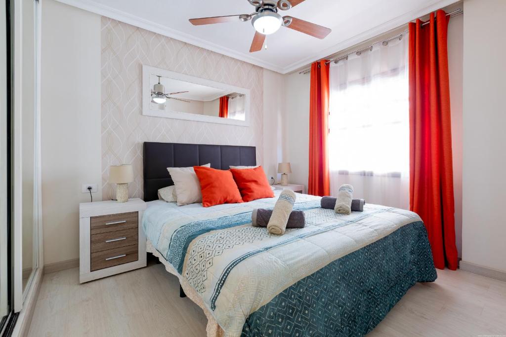 1 dormitorio con 1 cama grande y cortinas rojas en Modern apartment in Golf del Sur, AC237, tempered pool and ocean view, en San Miguel de Abona