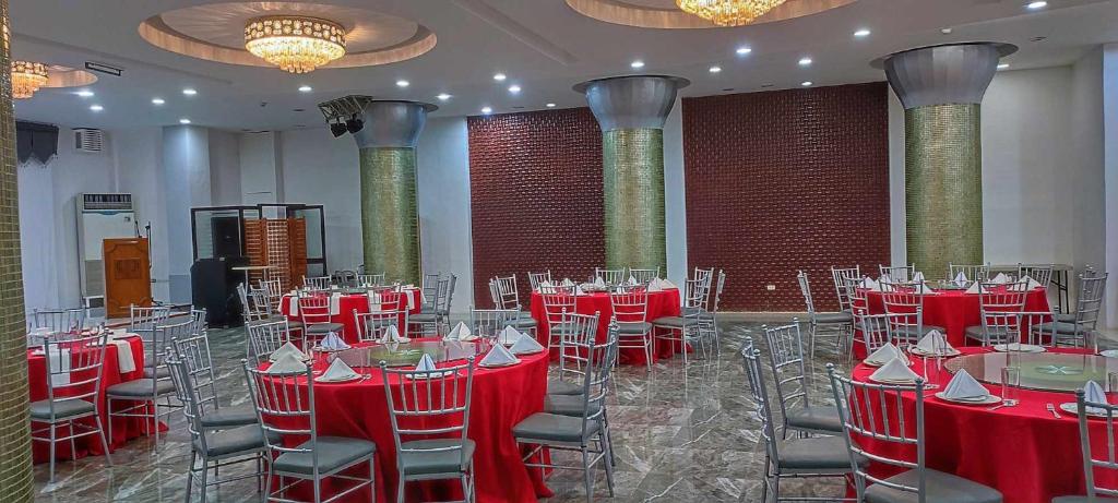 um salão de banquetes com mesas vermelhas e cadeiras numa sala em PHELA GRANDE HOTEL em General Santos