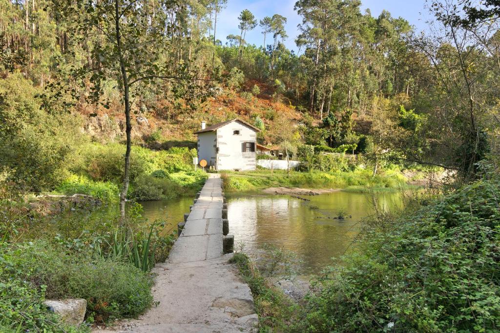 een klein huis aan de kant van een rivier bij Casa Azenha Branca in Esposende