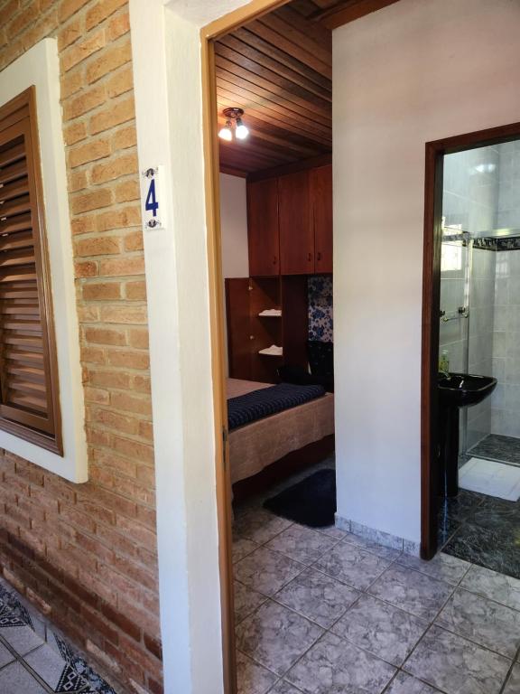 Un pasillo de una habitación con un dormitorio. en Pousada Pedacinho do Ceu suite Giulia 4, en Cunha