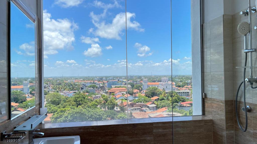 a bathroom with a view of a city from a window at Luxury Apartment near airport in Negombo