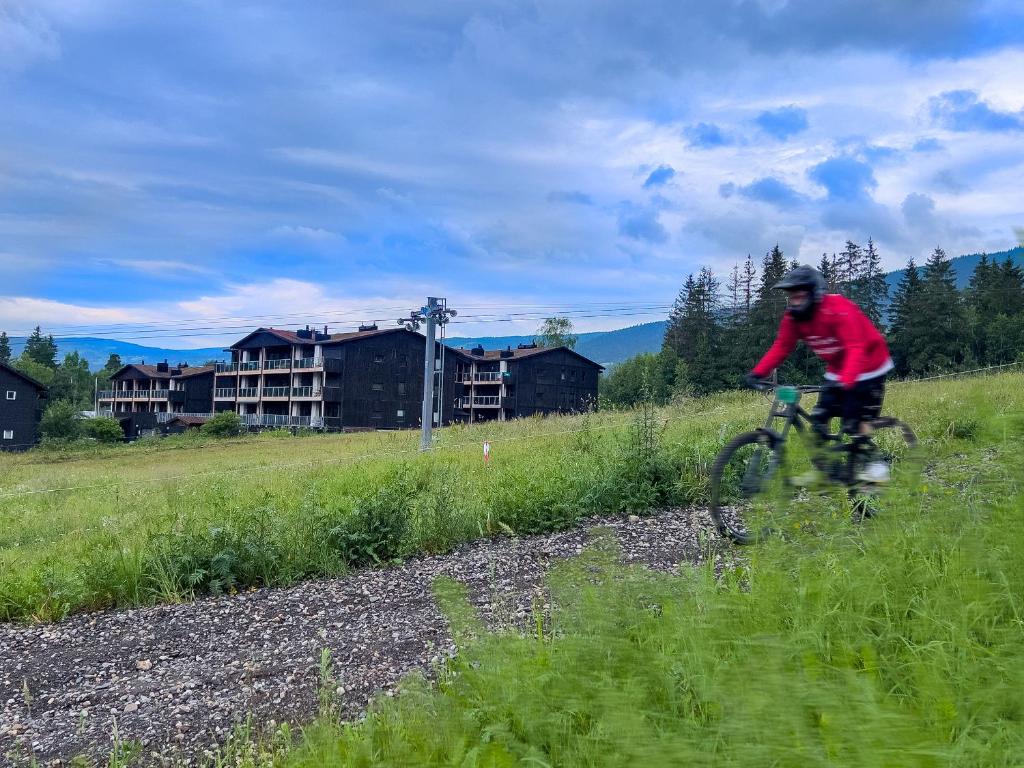 un hombre montando una bicicleta en un campo en Hafjelltunet, en Hafjell