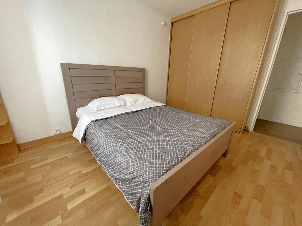 Schlafzimmer mit einem Bett und Holzboden in der Unterkunft Les Aubépines entre Disney et Paris in Champs-Sur-Marne