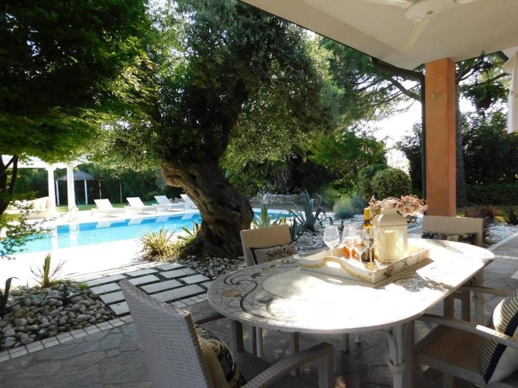 a white table and chairs next to a pool at Wonderful villa with pool on Albarella in Palazzo Vianello