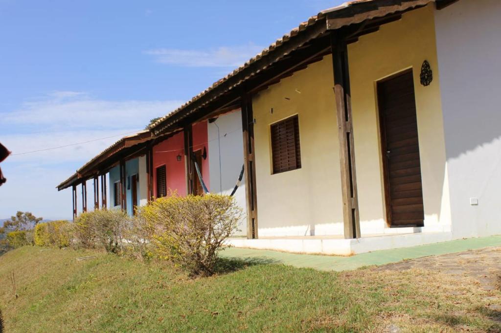 ein Gebäude auf einem Hügel neben einem Feld in der Unterkunft Chalé Canto da Seriema in Joanópolis