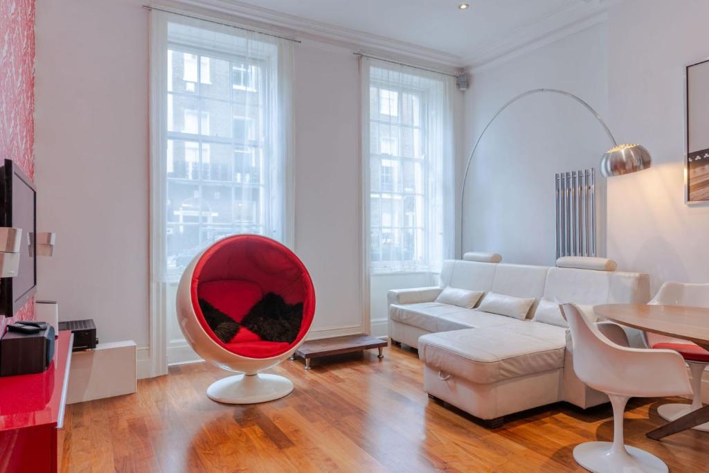 倫敦的住宿－The "Red Room Apartment" - Fitzrovia - by Frankie Says，带沙发和红色椅子的客厅