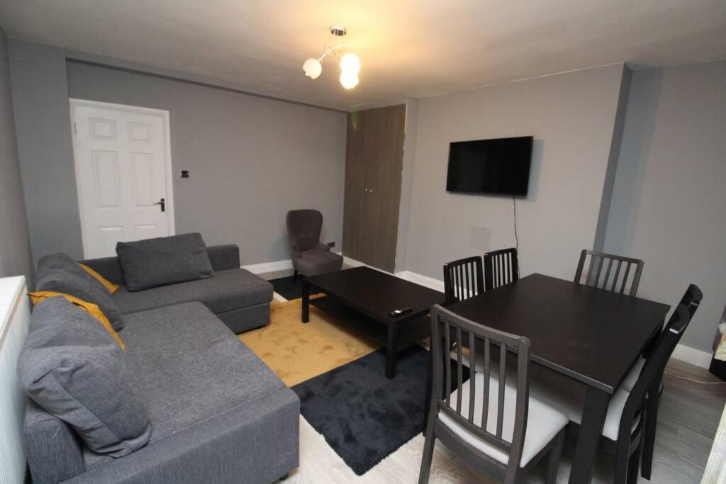 uma sala de estar com um sofá e uma mesa em Modern 2 Bed Close to City em Londres