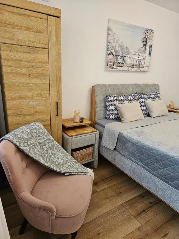 - une petite chambre avec un lit et une chaise dans l'établissement Vazov Apartment, à Kazanlak