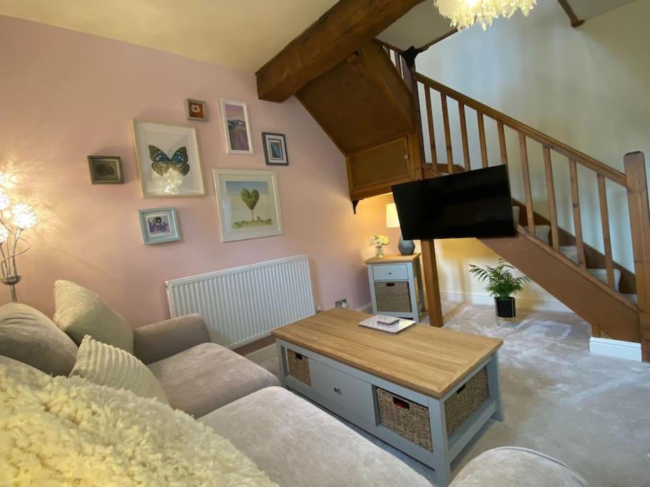 a living room with a couch and a tv at The Old Stable in Shifnal