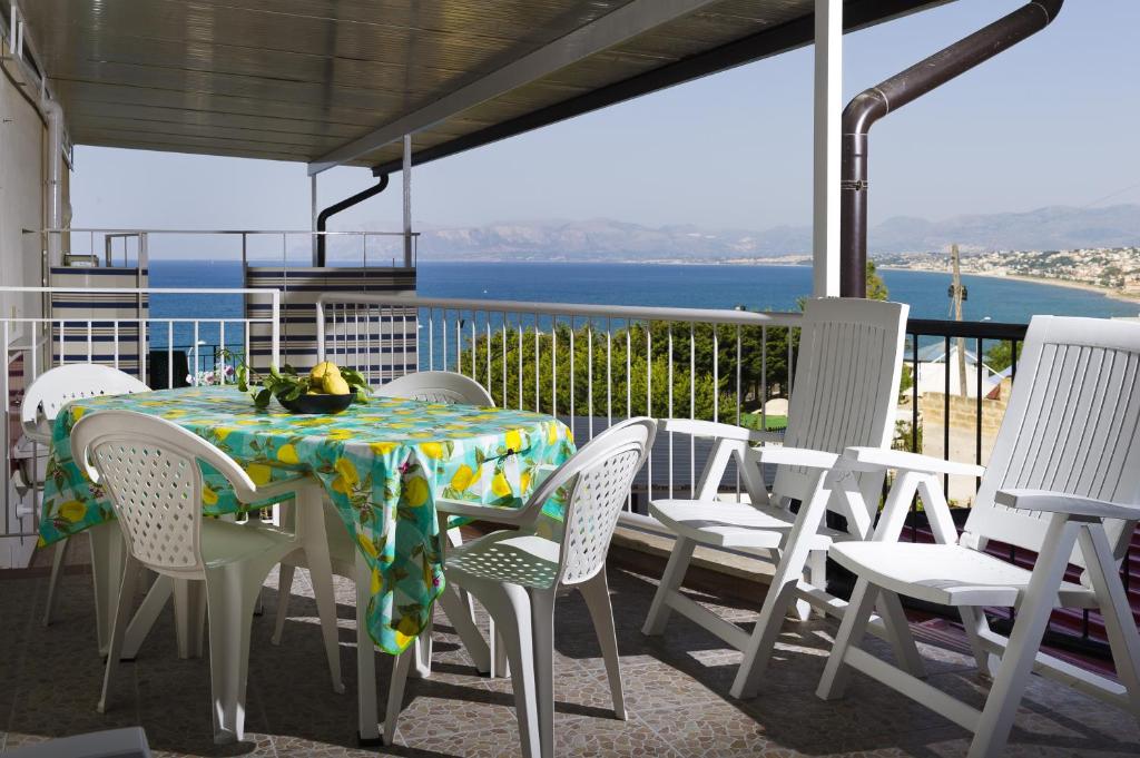 a table and chairs on a porch with a view of the ocean at Bivani a 100 m dal mare in Castellammare del Golfo