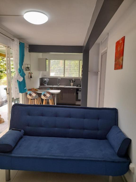 un sofá azul en una sala de estar con cocina en T2 Bambou en Fort-de-France