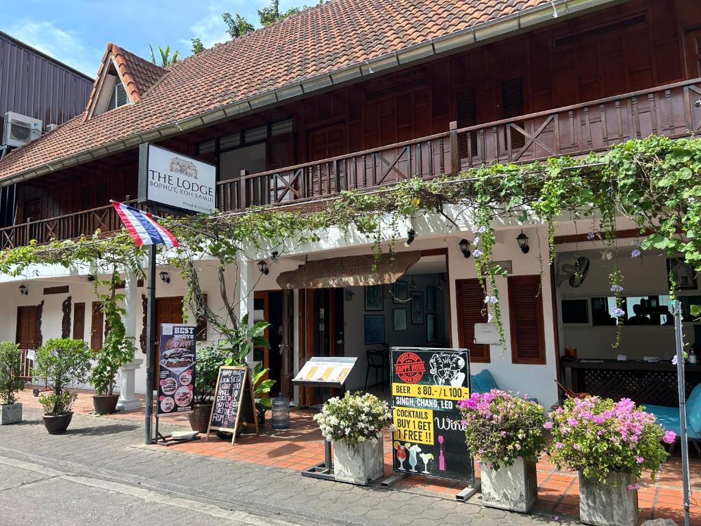 a building with signs and flowers in front of it at The Lodge in Bophut