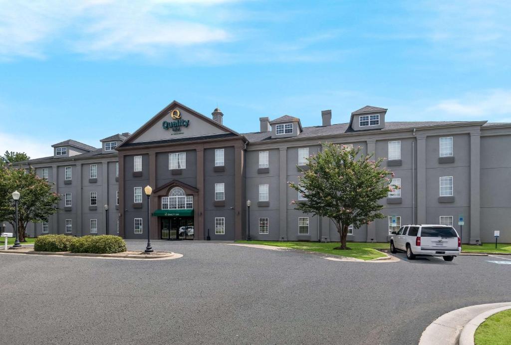 un bâtiment avec une voiture garée devant lui dans l'établissement Quality Inn near Seymour Johnson AFB, à Goldsboro