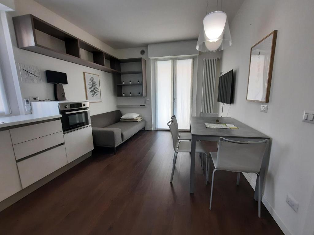 uma cozinha e sala de estar com uma mesa e um sofá em Locazione Turistica La Rosa - Navigatori em Verona