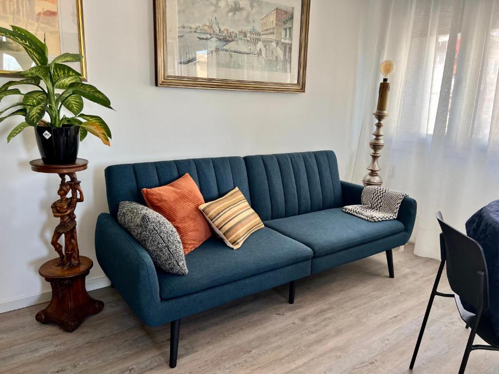 un sofá azul con almohadas en la sala de estar en Casa Silvano, en Mestre