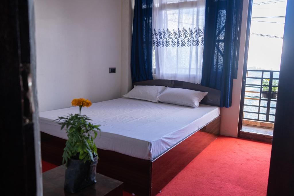 a small bedroom with a bed with a window at Bastola Basthan Homestay in Darjeeling